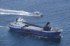 ヨットと衝突した砂利運搬船（手前）。奥は海上保安庁の巡視船＝大分県津久見市の保戸島沖で2025年8月13日午後0時59分、本社ヘリから