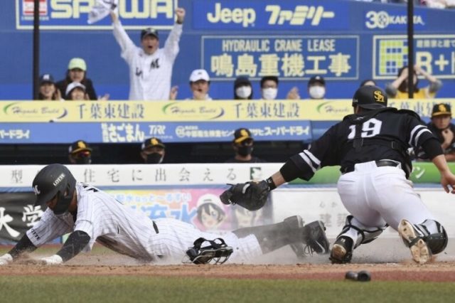 3回ロッテ一死二、三塁、角中の中犠飛で中継が乱れる間に三走に続いて二走中村奨が生還。捕手甲斐 (C)Kyodo News