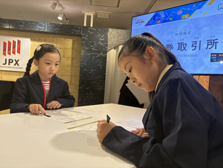 キッザニア東京の期間限定パビリオン「証券取引所」で、新規上場申請を体験する子供たち=18日、東京都江東区