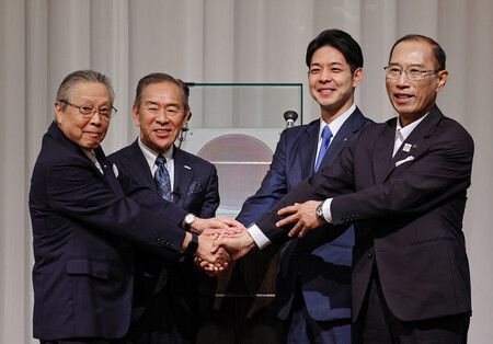 次世代半導体の試作品を披露した(左から)ラピダスの東哲郎会長、小池淳義社長、鈴木直道北海道知事、横田隆一千歳市長=18日、北海道千歳市