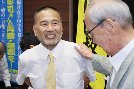 判決後の記者会見を終え、笑顔を見せる前川彰司さん(左)=18日午後、金沢市