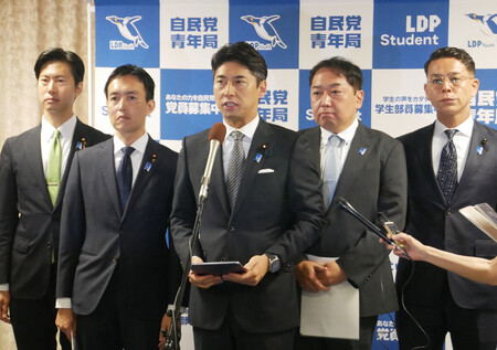 記者団の取材に応じる自民党の中曽根康隆青年局長(中央)ら=25日午後、東京・永田町