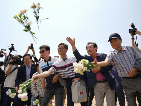 水没事故が起きた海底炭鉱「長生炭鉱」のある海に、花束を手向ける韓国側の遺族ら=6月18日、山口県宇部市