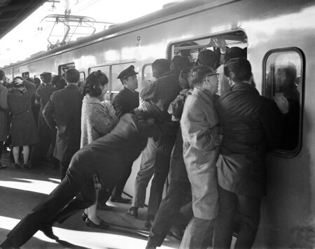 混雑する車内に乗客を押し込む国鉄職員=1967年12月、東京都新宿区の国鉄新宿駅