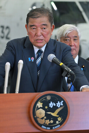 海上自衛隊の護衛艦「かが」を視察後、記者団の取材に応じる石破茂首相(手前)。奥は中谷元防衛相=23日午後、神奈川県横須賀市の海上自衛隊横須賀基地(代表撮影)