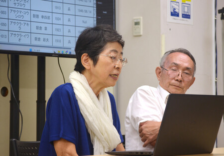 シベリア抑留の犠牲者名簿を読み上げる畑口佳代子さん(左)=23日午後、東京都新宿区