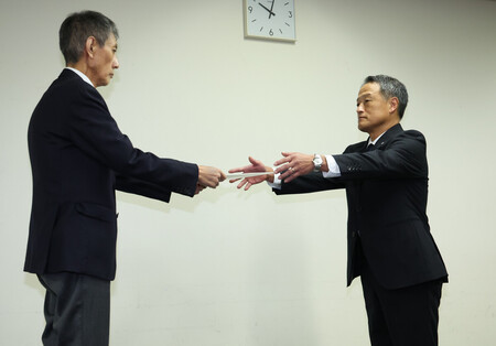 機長による飲酒問題で、国土交通省航空局の石井靖男安全部長(左)から厳重注意の文書を受け取る日本航空の中川由起夫常務=10日午前、東京・霞が関