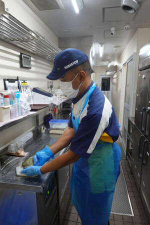 店内調理品の販売を再開したミニストップの店舗で、おにぎりを調理する店員=15日午後、千葉市
