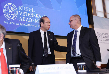 スウェーデン王立科学アカデミーでの記者会見を終え、共同受賞者のオマー・ヤギー氏(右)と言葉を交わす京都大の北川進特別教授=7日、ストックホルム