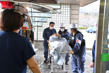 むつ総合病院の入院患者を、海上自衛隊の診療所へ搬送する隊員ら=9日午後、青森県むつ市(防衛省提供)