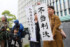 水俣病認定を巡る訴訟の控訴審判決で、「不当判決」などと書かれた紙を掲げる支援者ら＝２３日午後、福岡市