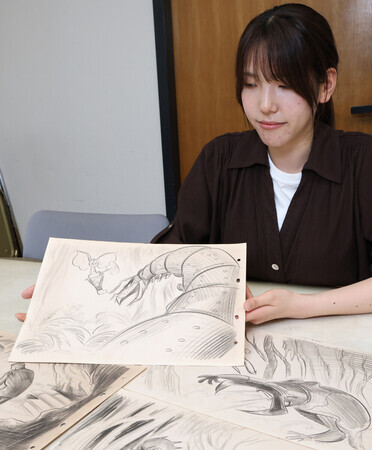 手塚治虫が執筆したイメージボードと手塚プロダクションの飯渕宏美さん=5月22日、埼玉県新座市(C)手塚プロダクション