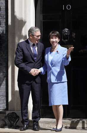 英国のスターマー首相(左)の出迎えを受ける高市早苗首相=14日、ロンドンの首相官邸