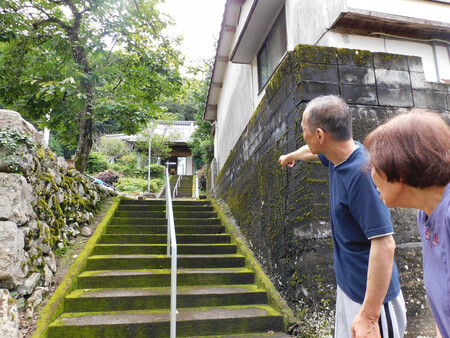 乗光寺の階段を指さして当時を振り返る住職の豊橋光秀さん(左)と母則子さん=1日、熊本県球磨村