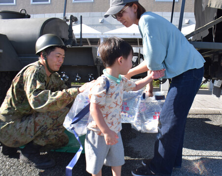 給水支援を受ける岡田愛さん(右)と春ちゃん(中央)=31日、熊本市