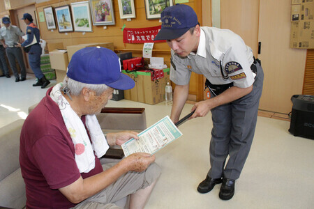 避難者に熱中症予防を呼び掛ける緊急消防援助隊員(右)=2日午後、熊本県八代市