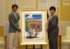 版画を受け取る小池都知事（右）とわたせせいぞうさん＝５日午後、都庁