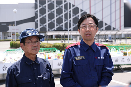 爆発事故で7人が死亡した「イオンモール熊本」で献花後、取材に応じる熊本県の木村敬知事(右)=11日午後、同県嘉島町