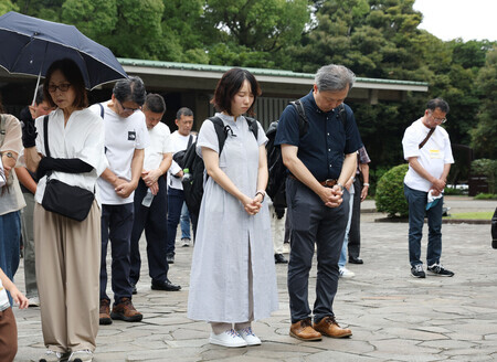 終戦から81年となり、千鳥ケ淵戦没者墓苑で正午の時報に合わせて黙とうする人たち=15日、東京都千代田区