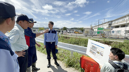 豪雨で氾濫した千葉県大網白里市の小中川を視察に訪れた熊谷俊人知事(左から4人目)=18日午後、同市
