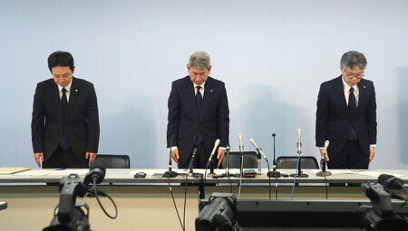 記者会見で頭を下げる四国電力送配電の青井久治常務(中央)ら=18日午後、徳島市