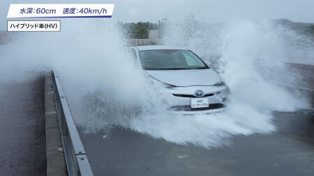 水深60センチの冠水路に水しぶきを巻き上げて進入するハイブリッド車=JAF提供
