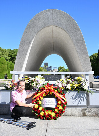 平和記念公園で原爆死没者慰霊碑に献花するドクさん=9日午前、広島市中区