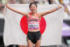 女子マラソンで7位入賞を果たし日の丸を手に笑顔を見せる小林（撮影・足立雅史）